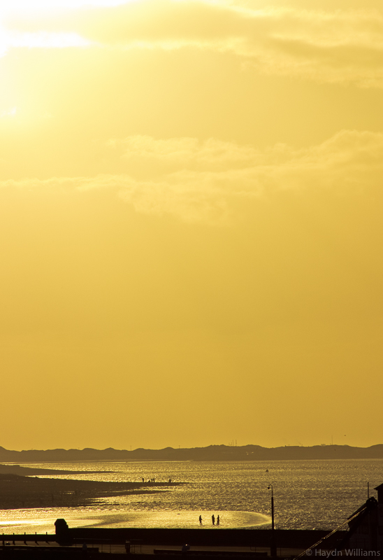 Sunset over the Menai Straits and the beach at Caernarfon.