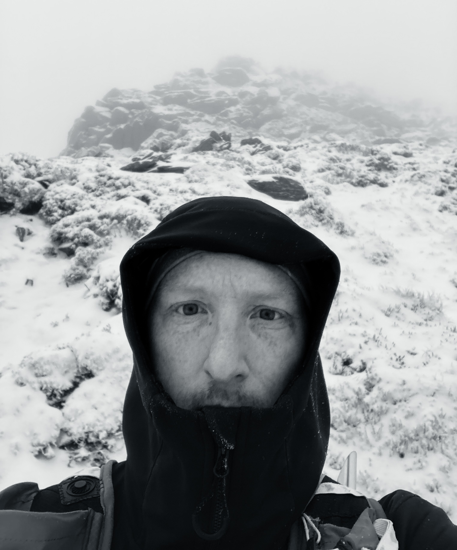 A person in winter coat on a snowy hillside. © Haydn Williams 2025